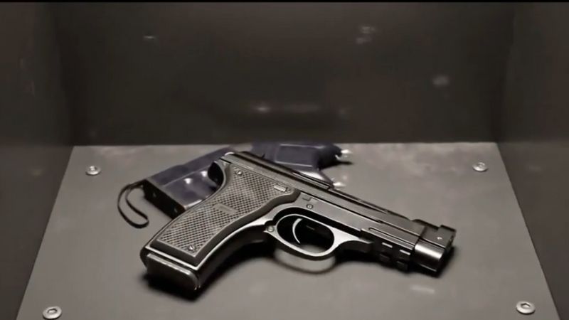 A handgun resting unsecured on a metal surface, highlighting risks tied to improper firearms storage