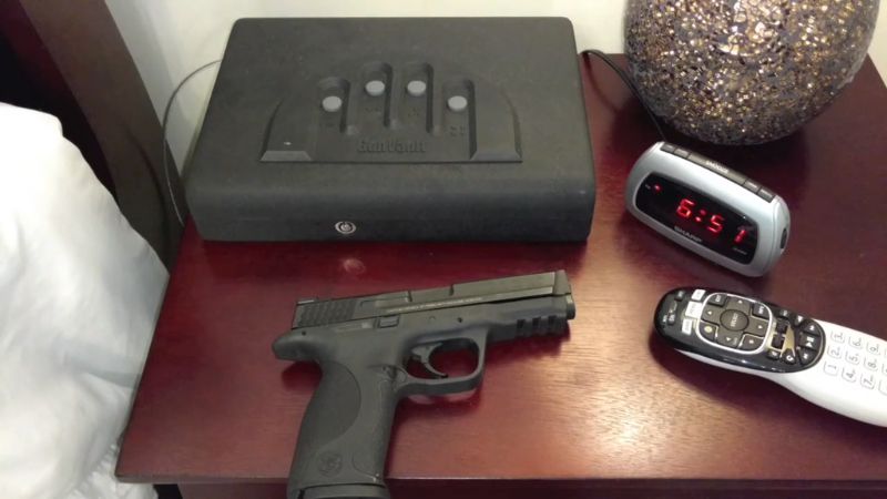 A handgun left unsecured on a nightstand next to a locked safe