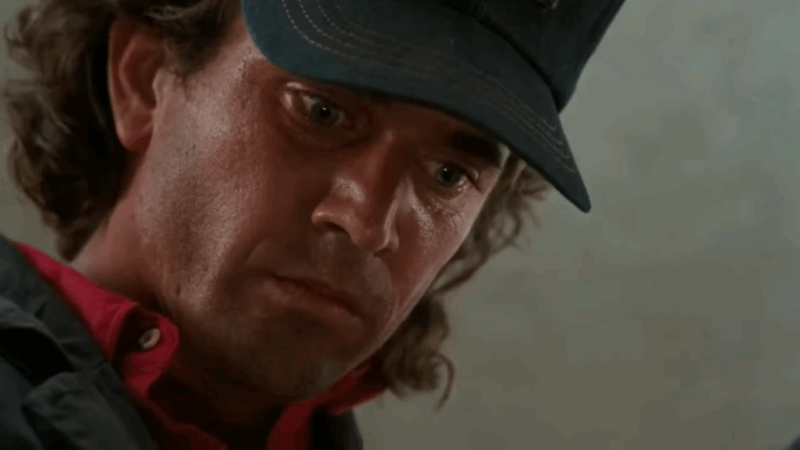 Martin Riggs stares intensely, visibly haunted, reflecting the weight of his military past and personal loss