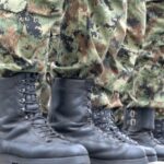 Soldiers stand in formation wearing camouflage uniforms and black boots during military training events in the US