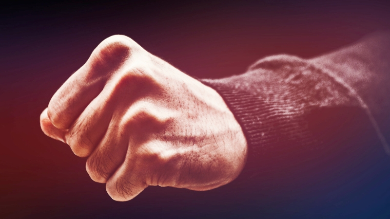 A close-up of a clenched fist symbolizing the US Army’s prohibition on domestic violence in background checks