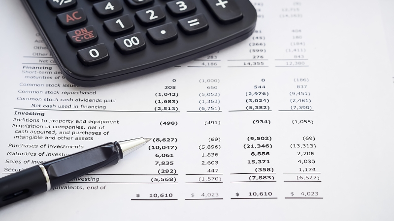 A calculator and pen on a financial statement for a US Army financial history and credit check