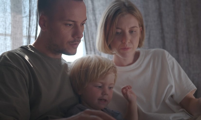 Parents reading a book to a child