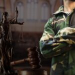 A soldier in camouflage stands beside a Lady Justice statue and gavel, symbolizing legal challenges in military entry